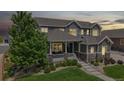 Charming two-story home featuring inviting front porch and well-maintained landscaping at dusk at 3891 W 149Th Ave, Broomfield, CO 80023
