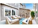 Cozy patio with stone fireplace, comfortable seating, and stylish blue striped rug at 3891 W 149Th Ave, Broomfield, CO 80023