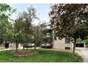 Apartment building exterior and grassy lawn, with trees surrounding it at 636 N Washington St # 301, Denver, CO 80203