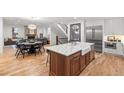 Open kitchen with large island, farmhouse sink, stainless steel appliances and hardwood floors at 2056 S Ogden St, Denver, CO 80210