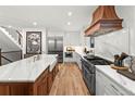 Spacious kitchen featuring a large island, custom range hood, and modern appliances at 2056 S Ogden St, Denver, CO 80210