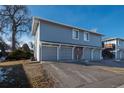 Gray building with three attached garages and driveway at 7933 York St # 1, Denver, CO 80229