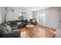 Living room with sectional sofa, coffee table, and hardwood floors at 7933 York St # 1, Denver, CO 80229