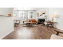Open-concept living room with fireplace, wood floors, and natural light at 5745 W Atlantic Pl # 108, Lakewood, CO 80227