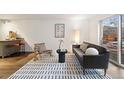 Living room featuring modern decor, an accent rug, and a breakfast bar with orange barstools at 1032 N Clarkson St # 201, Denver, CO 80218
