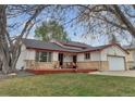 Quaint ranch-style home with a welcoming front porch and lush green lawn at 12079 E Louisiana Ave, Aurora, CO 80012