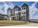 Charming townhome exterior featuring modern design, brick accents, and a inviting covered balcony on a sunny day at 657 Harness St, Erie, CO 80516