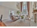 Bright living room featuring soaring ceilings, large windows, fireplace, and neutral color palette at 8053 E Maple Ave, Denver, CO 80230