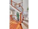 Elegant staircase with wood railing, iron spindles and carpeted steps leading to the upper level at 8053 E Maple Ave, Denver, CO 80230