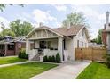 Lovely painted brick home showcasing a well-kept lawn and welcoming front porch at 4261 Julian St, Denver, CO 80211