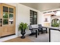 Inviting porch with modern chairs, plants, and beautiful natural wood door at 4261 Julian St, Denver, CO 80211