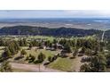 Breathtaking aerial view of the property nestled in a scenic landscape with distant lake views at 25392 Westridge Rd, Golden, CO 80403