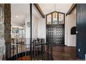 Inviting foyer with a stone accent wall, modern chandelier, hardwood floors, and staircase at 25392 Westridge Rd, Golden, CO 80403