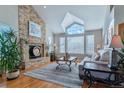 Bright living room featuring a stone fireplace, large windows, and comfortable seating creates an inviting atmosphere at 6590 S Tabor St, Littleton, CO 80127