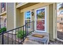 Inviting front entryway with a concrete step, black railing, and decorative wreath on the glass door at 1811 S Quebec Way # 221, Denver, CO 80231