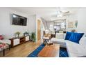 Bright living room with hardwood floors, white sofa, blue rug, and contemporary decor at 1811 S Quebec Way # 221, Denver, CO 80231