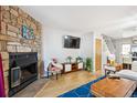 Cozy living room featuring a stone fireplace, hardwood floors, and contemporary furnishings at 1811 S Quebec Way # 221, Denver, CO 80231