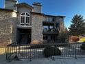 Charming condo building with stone facade, balconies, and mature landscaping offers a inviting curb appeal at 2575 S Syracuse Way # M108, Denver, CO 80231