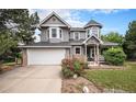 Charming two-story home boasts a unique turret, stone accents, well-manicured lawn, and an attached two-car garage at 5491 S Youngfield W Ct, Littleton, CO 80127