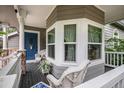 Spacious front porch offers seating and a view of the lush surroundings, creating a welcoming outdoor space at 5491 S Youngfield W Ct, Littleton, CO 80127