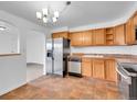 Inviting kitchen with stainless steel appliances, ample wood cabinetry, and tile flooring at 1746 S Alcott St, Denver, CO 80219
