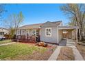A charming home features a covered carport and a lovely front porch at 640 S Quivas St, Denver, CO 80223