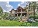 Expansive backyard with a multi-level stone patio, lush greenery, and a spacious lawn, ideal for outdoor entertaining at 1105 Northwood Ln, Castle Rock, CO 80108