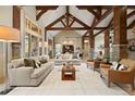 Bright living room with high vaulted ceilings, exposed wooden beams, stone accents, and an open floor plan at 1105 Northwood Ln, Castle Rock, CO 80108