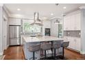 Modern kitchen featuring a large island with seating, stainless steel appliances, and designer finishes at 2746 Geneva St, Denver, CO 80238