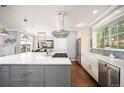 Bright kitchen with gas cooktop on island, stainless appliances, mosaic tile backsplash, and hardwood floors at 2746 Geneva St, Denver, CO 80238