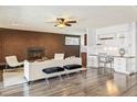 Cozy living room featuring a brick fireplace, built-in desk, and wood laminate flooring at 5432 E Bails Dr, Denver, CO 80222