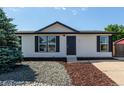 Inviting one-story home with a manicured front yard and modern black accents at 657 Locust Ave, Lochbuie, CO 80603