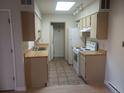 Bright kitchen with tile flooring, skylight, and white appliances at 1845 N Kendall St # 316D, Lakewood, CO 80214
