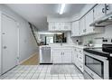Well-lit kitchen with white cabinets, stainless steel dishwasher and staircase access at 19804 Summerset Ln, Parker, CO 80138