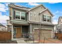 Two-story home with neutral-colored siding, solar panels, stone accents, and a tan garage door at 10125 Zeno St, Commerce City, CO 80022