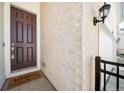 Close-up of a stylish front door with a welcome mat, complemented by a brick wall and sconce lighting at 195 Silver Rock Trl, Castle Rock, CO 80104