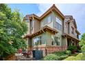 Green townhouse exterior with brick accents, multiple windows, and landscaped backyard at 10134 Bluffmont Ln, Lone Tree, CO 80124