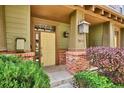Close-up of a front porch with a yellow door, brick accents and manicured bushes at 10134 Bluffmont Ln, Lone Tree, CO 80124