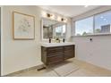Modern bathroom featuring a double vanity, stylish mirror, patterned accent wall, and natural light at 4991 S Beeler. St, Greenwood Village, CO 80111