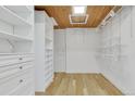 Spacious walk-in closet with custom shelving, wood floors, and a skylight, offering ample storage at 4991 S Beeler. St, Greenwood Village, CO 80111