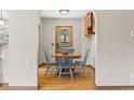 Cozy dining room featuring a round wooden table, hardwood floors, and bright blue chairs at 30313 Arena Dr, Evergreen, CO 80439