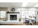 Cozy living room with a white brick fireplace, decorative mantle, and adjacent breakfast nook at 1288 Gambel Oaks Dr, Elizabeth, CO 80107