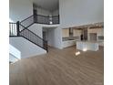 Spacious living area with hardwood floors that connects the staircase and kitchen at 1667 Fox Trotter Pt, Castle Rock, CO 80104