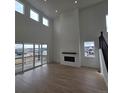 Open-concept living room with high ceilings, a fireplace, and access to a deck at 1667 Fox Trotter Pt, Castle Rock, CO 80104