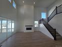 Bright living room with tall ceilings, fireplace, large windows, and sliding glass doors to the patio at 1667 Fox Trotter Pt, Castle Rock, CO 80104