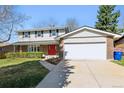 Lovely two-story home featuring brick accents, a red door and an attached two car garage at 1395 Abilene Dr, Broomfield, CO 80020