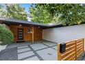 Stylish front porch featuring wood accents, a modern mailbox, and decorative concrete pavers at 7036 S Apache St, Littleton, CO 80120