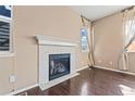 Close-up of a tiled fireplace in a room with hardwood floors and natural light coming through the window at 21893 E Layton Dr, Aurora, CO 80015