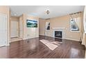 Bright living room with hardwood floors features a fireplace, large TV, and neutral walls, creating a welcoming atmosphere at 21893 E Layton Dr, Aurora, CO 80015