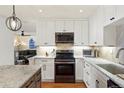 Modern kitchen featuring white cabinets, granite countertops, and stainless steel appliances at 7192 S Vine E Cir, Centennial, CO 80122